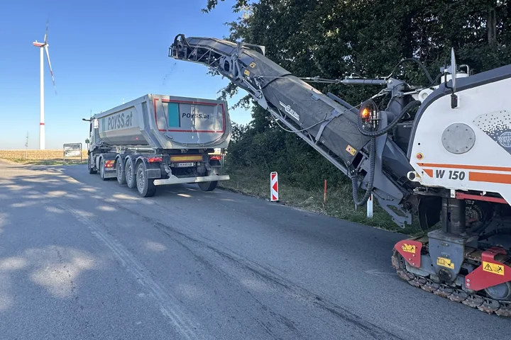 Asphaltfräse übergibt Fräsgut an einen LKW