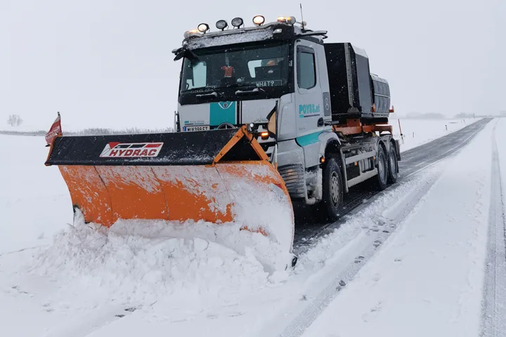 Poyss-LKW mit Schneepflug räumt eine Straße