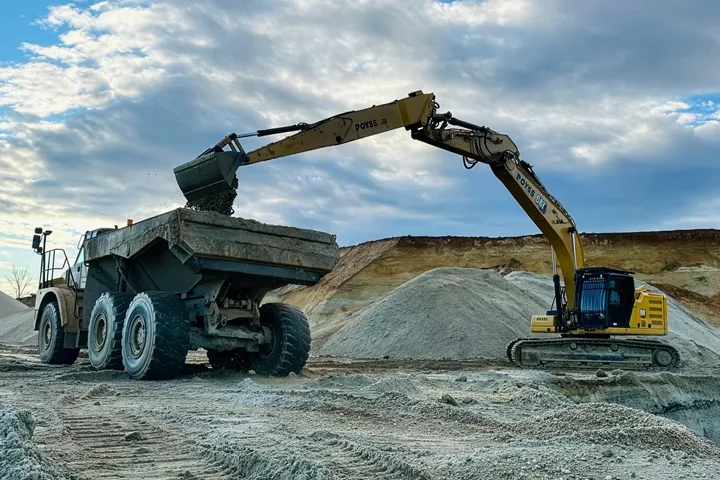 Poyss Bagger belädt Dumper mit Aushubmaterial auf der Baustelle
